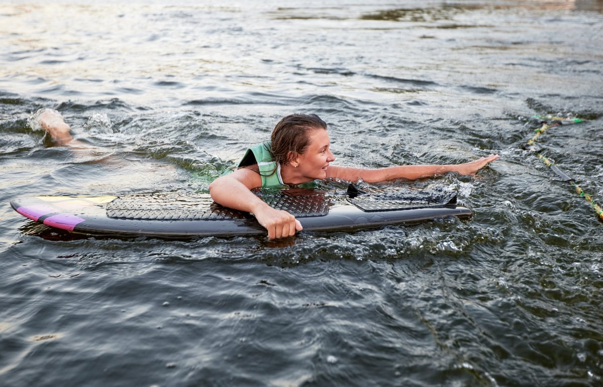 Wakeboarder preparing to launch off a sport boat on an Arizona lake